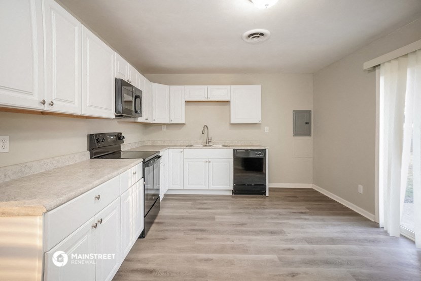 an empty kitchen with white cabinets and stainless steel appliances