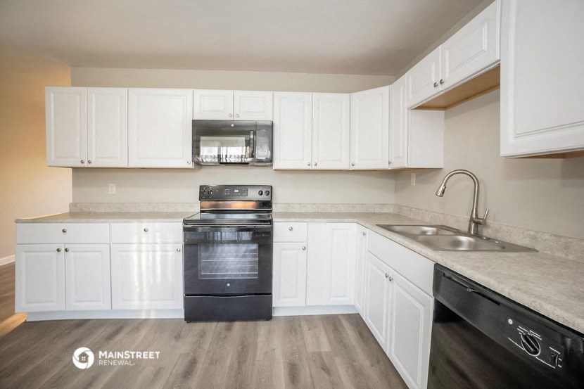 a kitchen with white cabinets and black appliances and a sink
