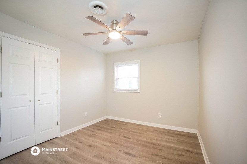 a bedroom with a ceiling fan and a closet