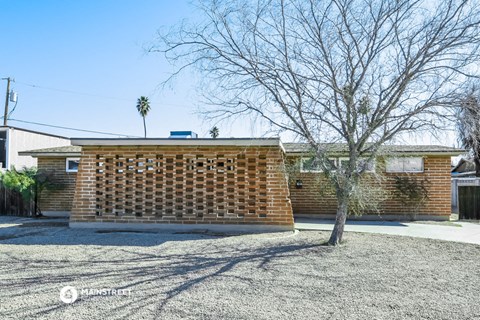 a brick garage with a tree in front of it