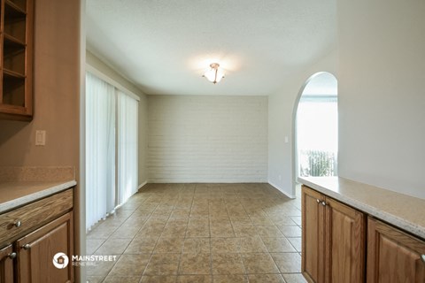 an empty kitchen and dining room with a large window