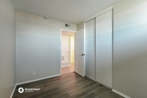 a master bedroom with a large closet and a door to the bathroom