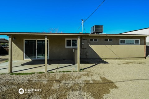 an old house with a driveway and a blue sky