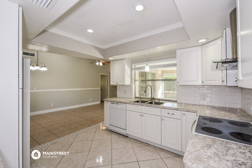 a kitchen with white cabinets and a sink and a counter top