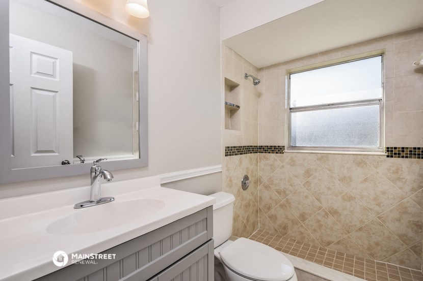 a bathroom with a toilet and a sink and a mirror