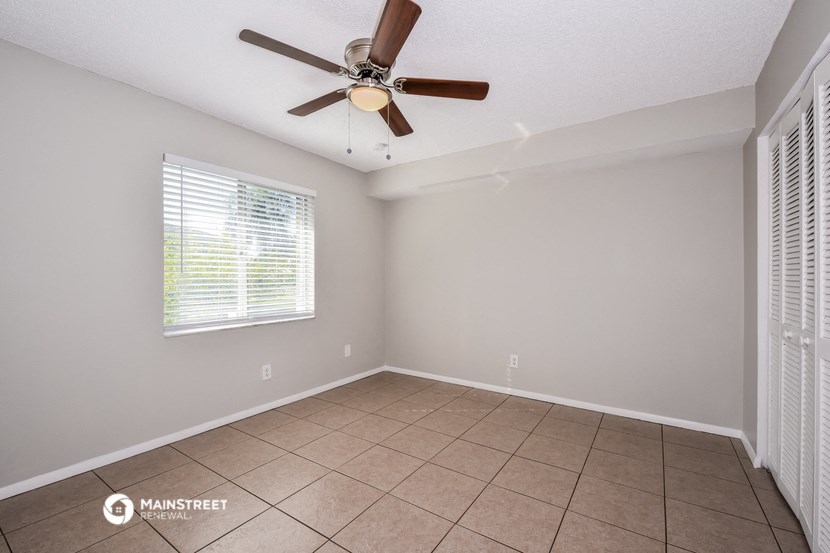 a living room with a ceiling fan and a tiled floor