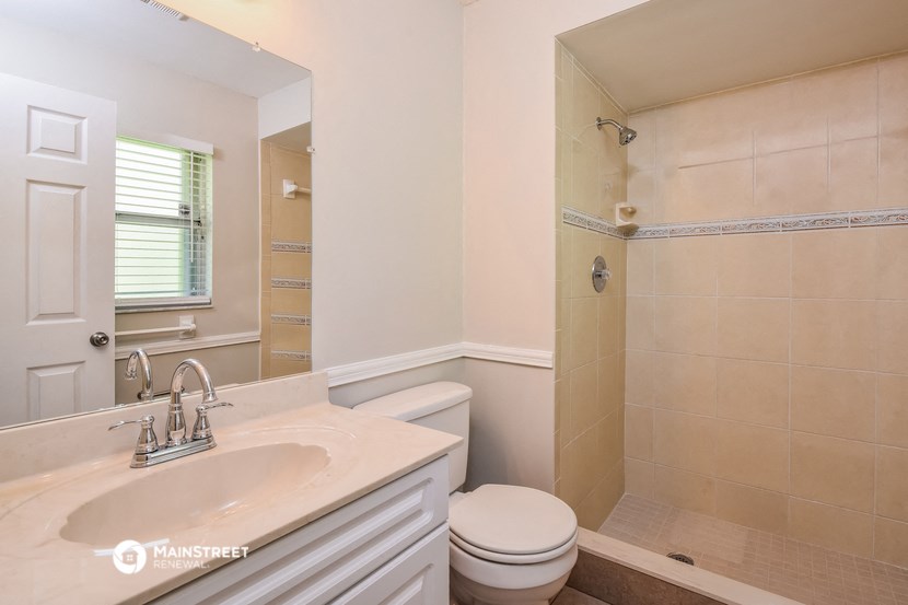 a bathroom with a toilet and a sink and a shower