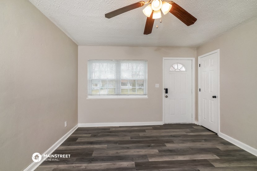 the living room of a home with a ceiling fan and a window