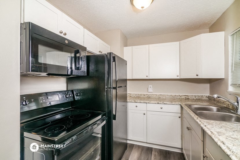 a kitchen with stainless steel appliances and white cabinets