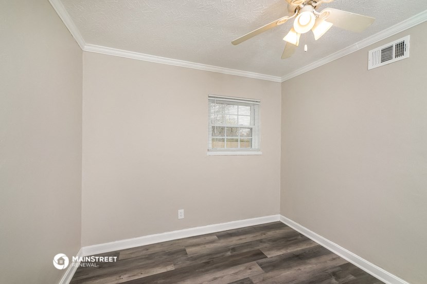 the interior of a bedroom with a ceiling fan and a window