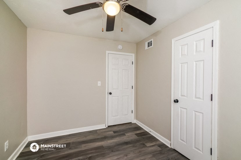 the living room of our studio apartment atrium with two doors and a ceiling fan
