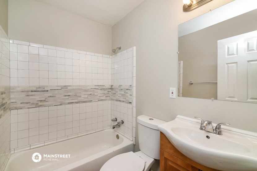 a bathroom with a toilet sink and tub and a mirror