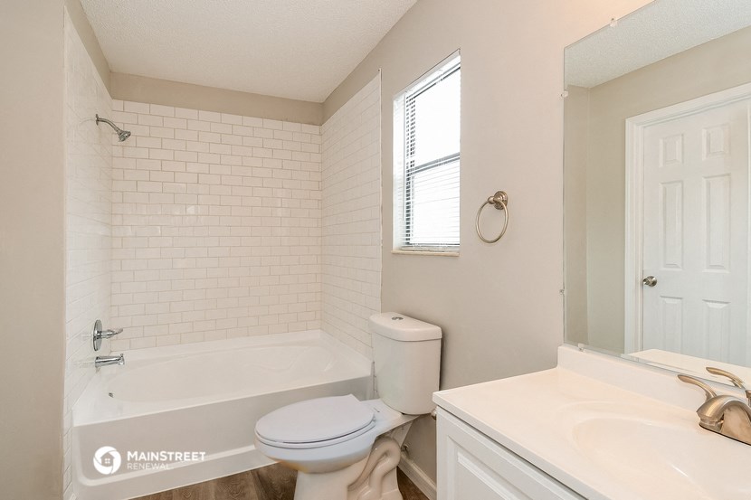 a white bathroom with a tub and a toilet and a sink