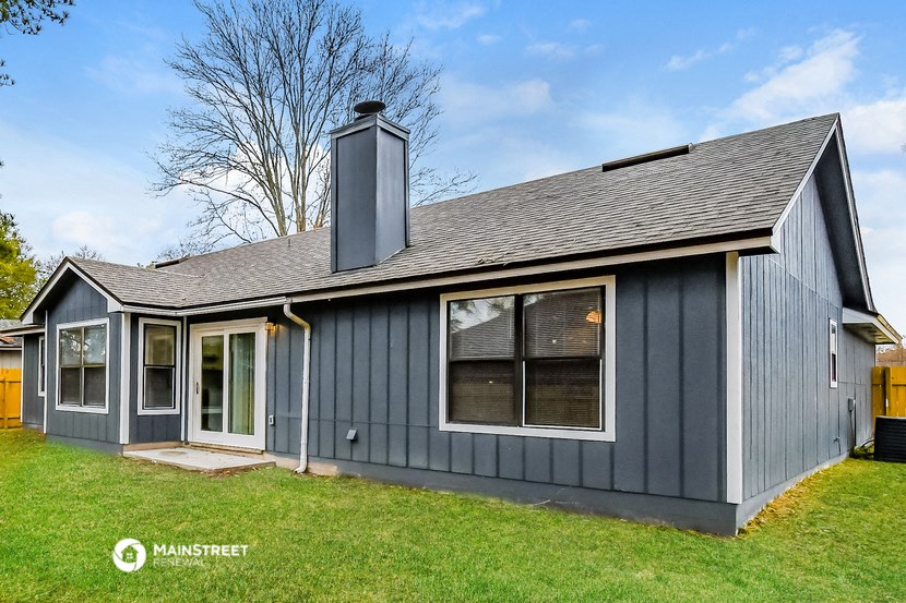 the exterior of a gray house with a grey roof
