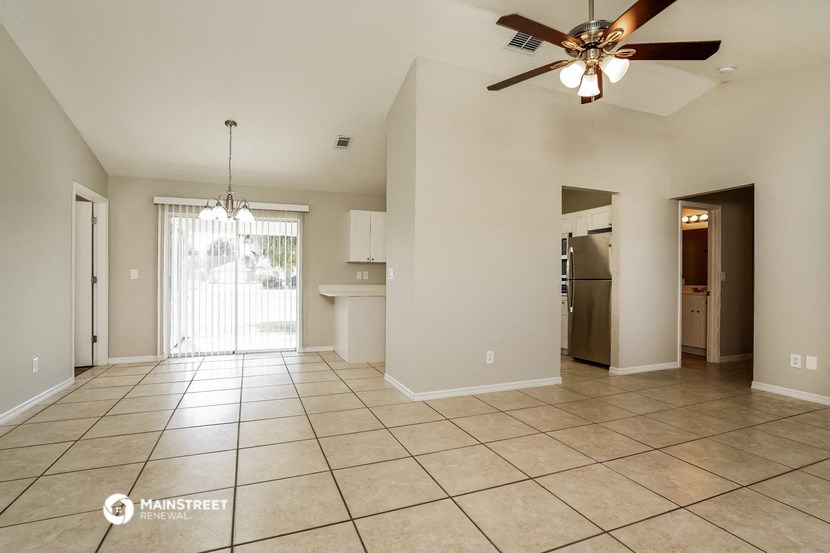an empty living room with a ceiling fan