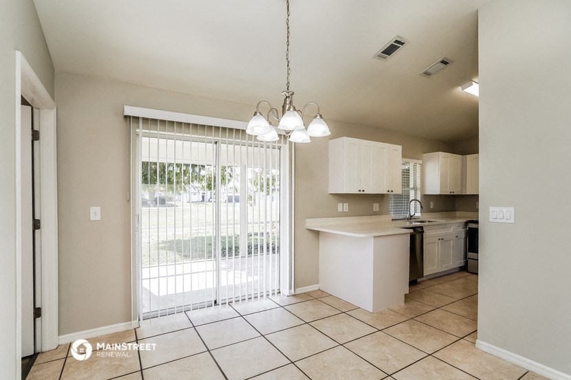 a kitchen with a sliding glass door leading to the patio