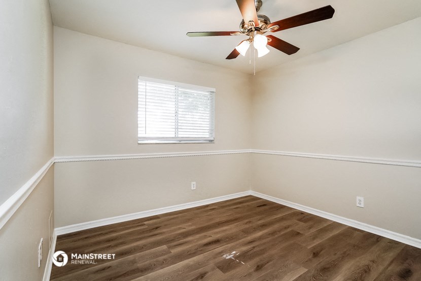 the bedroom with hardwood flooring and a ceiling fan