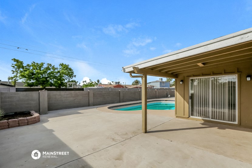 a patio with a pool in the backyard of a house