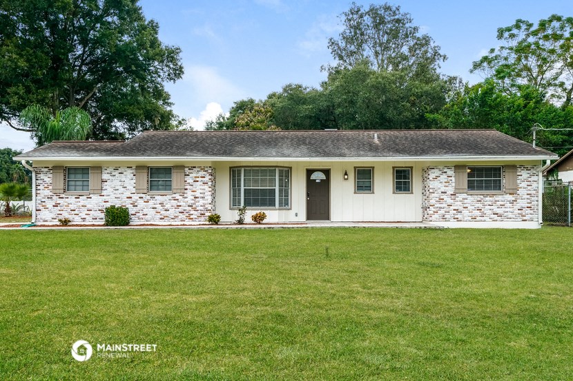a white brick house with a lawn in front