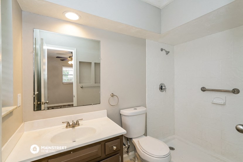 a bathroom with a sink toilet and a mirror