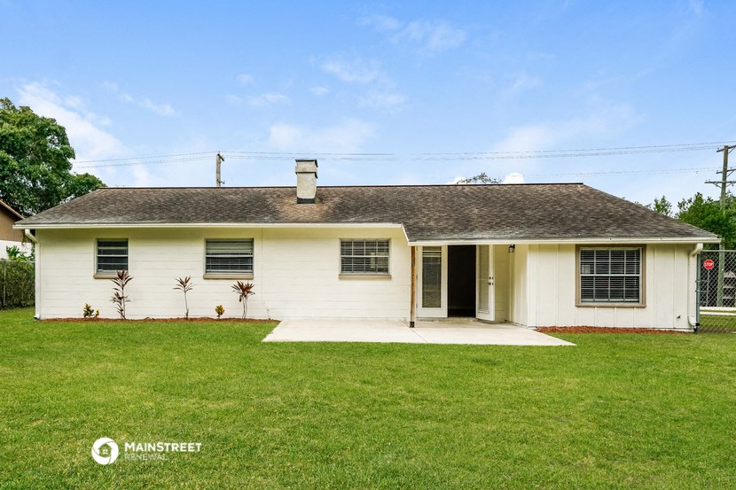 a white house with a green lawn and a blue sky