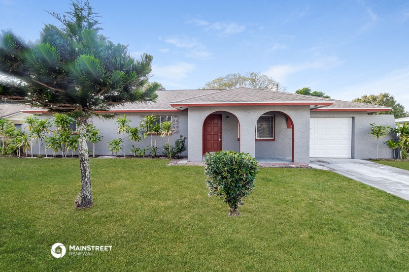 a house with a lawn and a palm tree