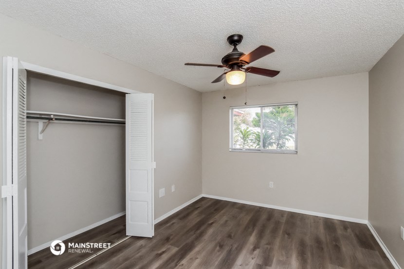 a bedroom with a ceiling fan and a closet