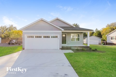 a house with a white driveway and a green lawn