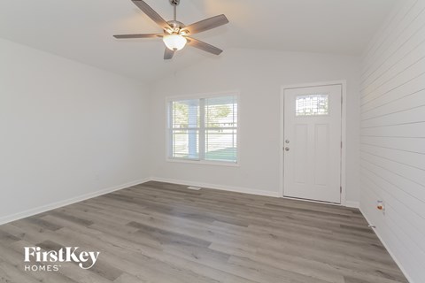 a bedroom with white walls and a ceiling fan