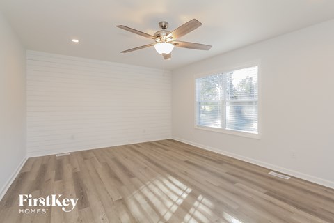 a living room with wood floors and a ceiling fan