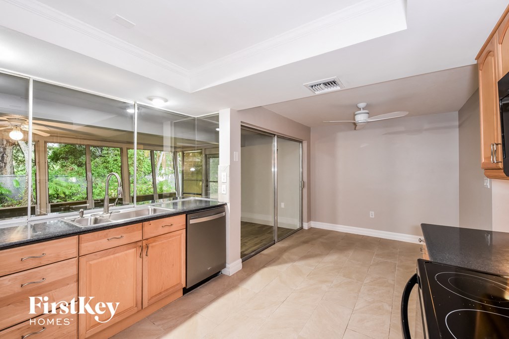 A kitchen with a black counter top and wooden cabinets.