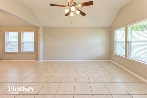 the living room of an empty house with a ceiling fan