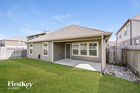 a backyard with a house with a lawn and a patio