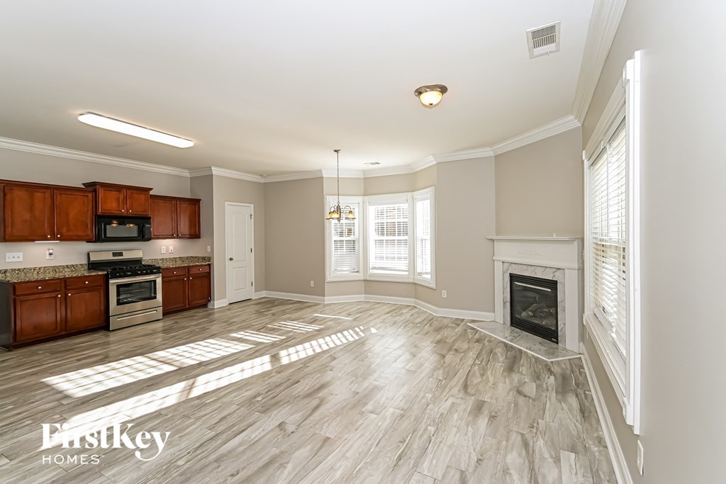 A spacious kitchen and living room with wood flooring and a fireplace.