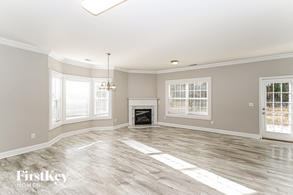 A spacious living room with a fireplace and a chandelier.