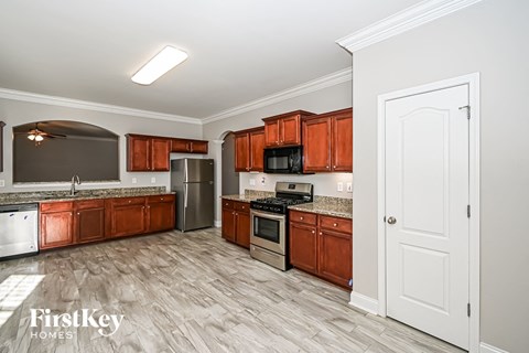 A kitchen with wooden cabinets and a white door.