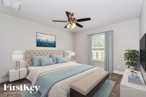 A bedroom with a large bed and a ceiling fan.