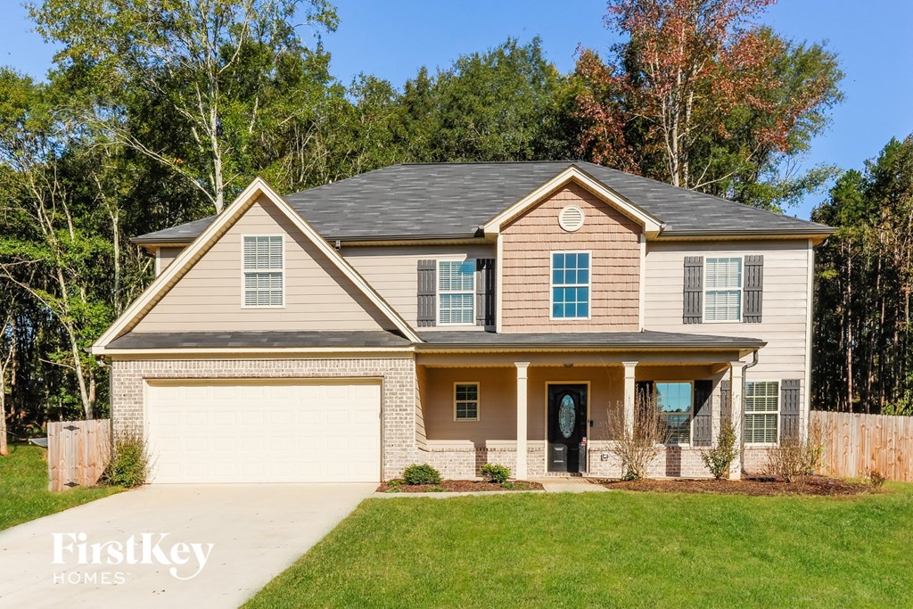 a beige house with a garage and a lawn