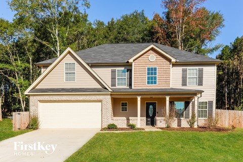 a beige house with a garage and a lawn