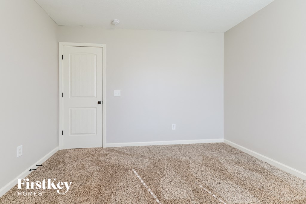 a empty room with carpet and a white door