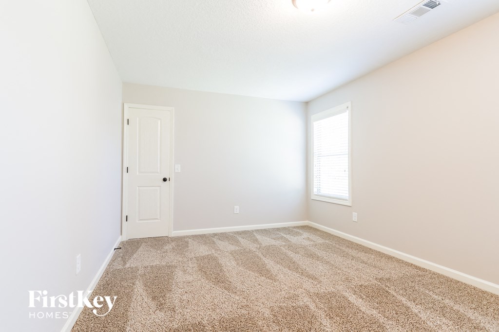 an empty room with carpet and a white door