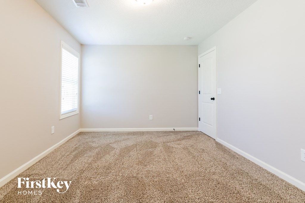 a room with a carpeted floor and a white door