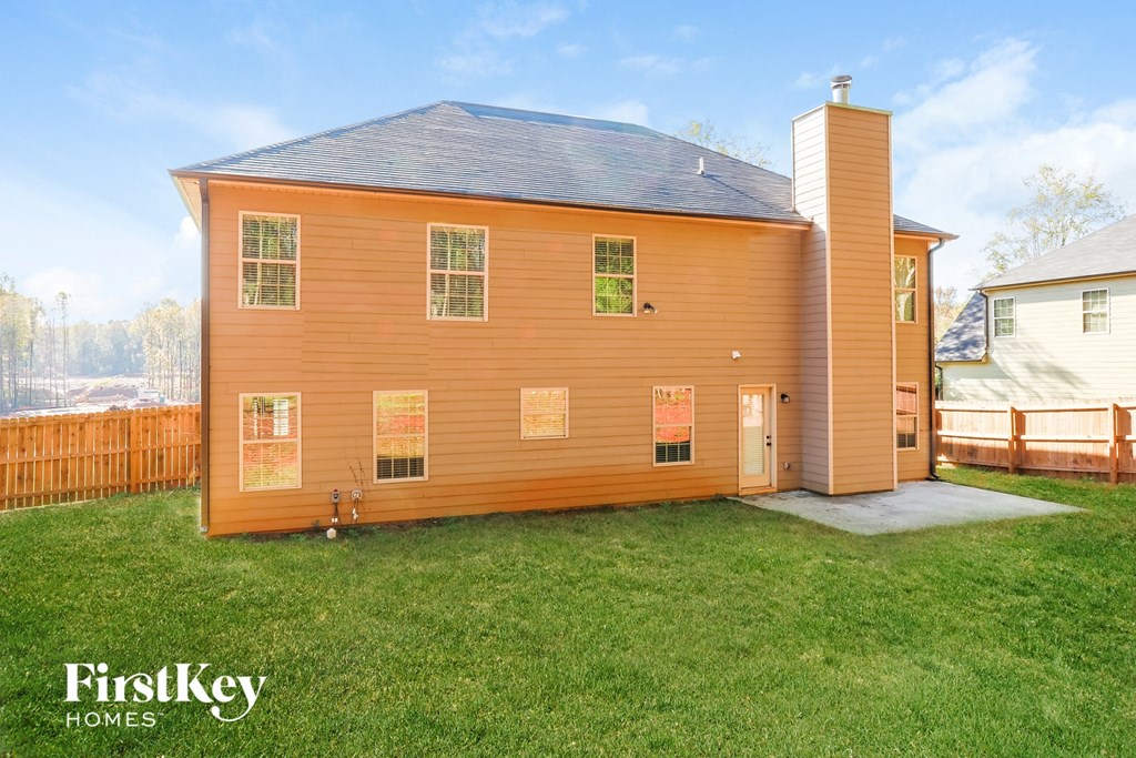 the back of a house with a backyard and a fence