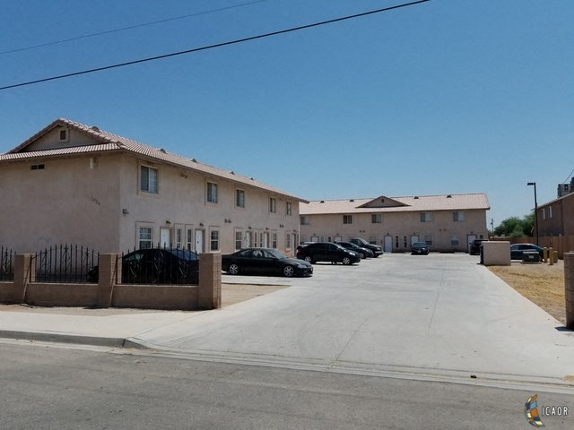 a row of buildings with cars parked in front of them