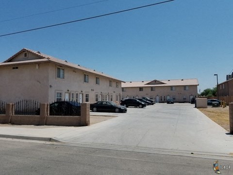 a row of buildings with cars parked in front of them