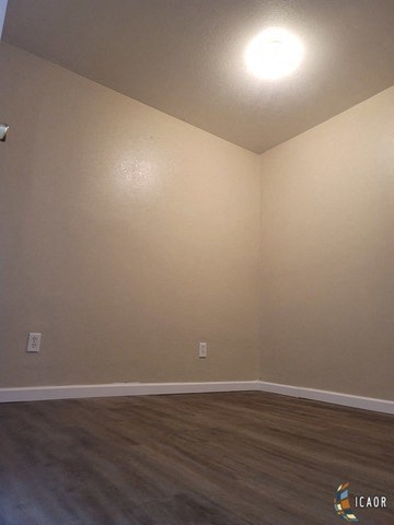 an empty room with white walls and wooden floors