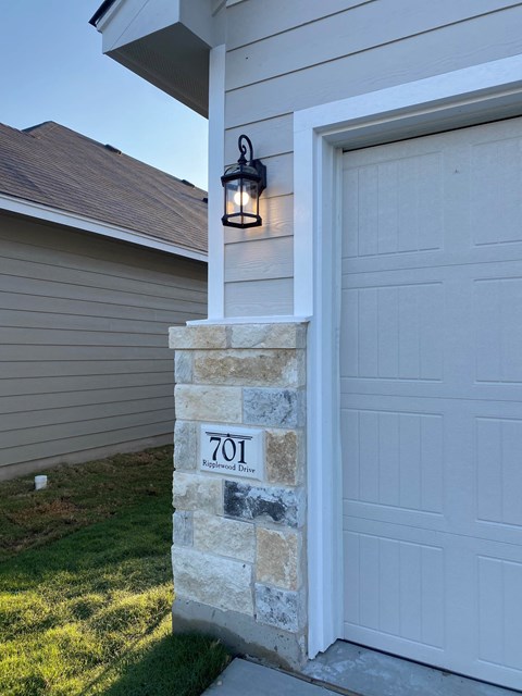 a white garage door with a light on the side of a house