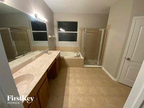 A bathroom with a sink, mirror, and shower.