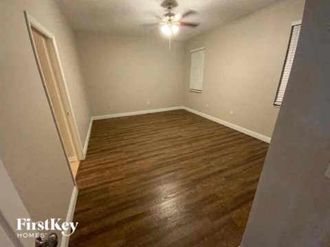 A room with wooden flooring and a ceiling fan.