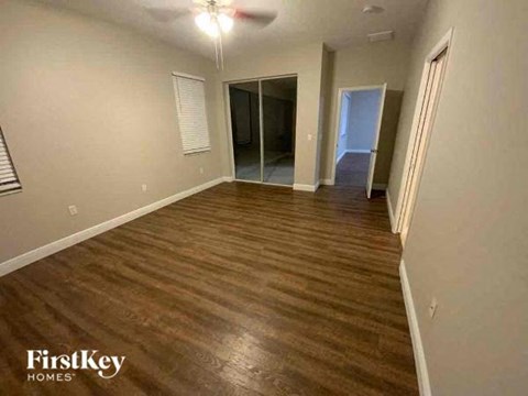 A room with wooden flooring and a sliding glass door.